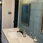 The Sevilla Mosaic Tiles, Original KitKat design in an Ocean Green, with a size of 20x145mm installed on a bathroom wall. A vanity unit in front with a sink. 2 mirrors mounted to the tile wall.